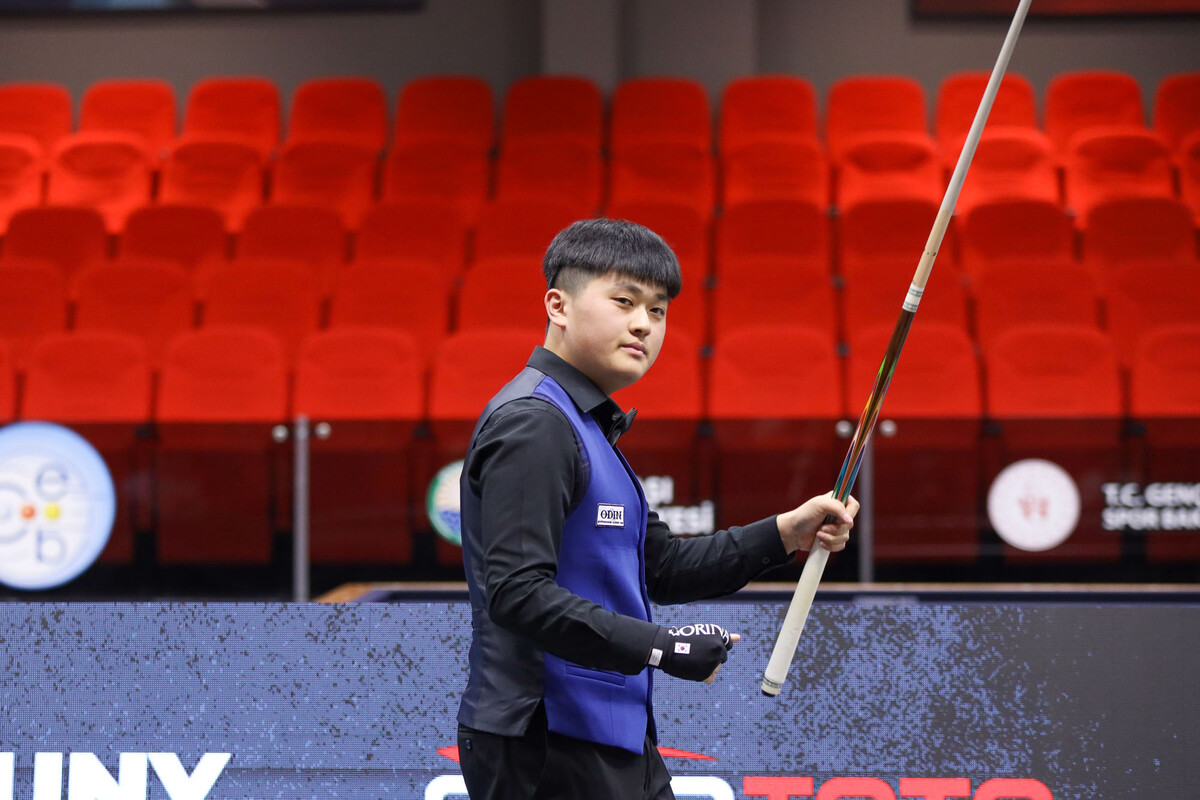 챔피언십포인트를 득점한 오명규가 큐를 들고 주먹을 불끈 쥐고 있다.