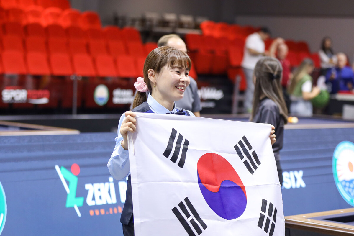 '제11회 세계여자3쿠션선수권대회'에서 우승 당시 이신영이 태극기를 펼쳐 들고 기뻐하고 있다. 사진=파이브앤식스 제공