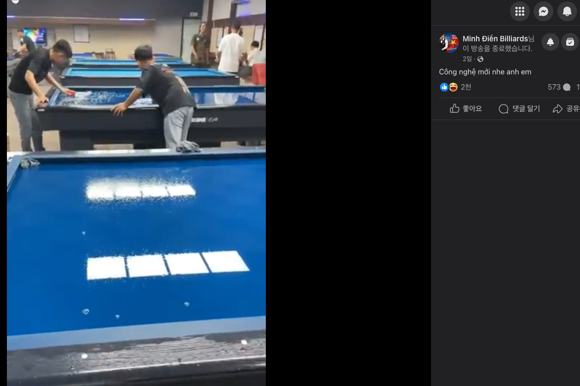 두 남성이 아주 정성 들여 당구대를 물로 씻어내고 있다.