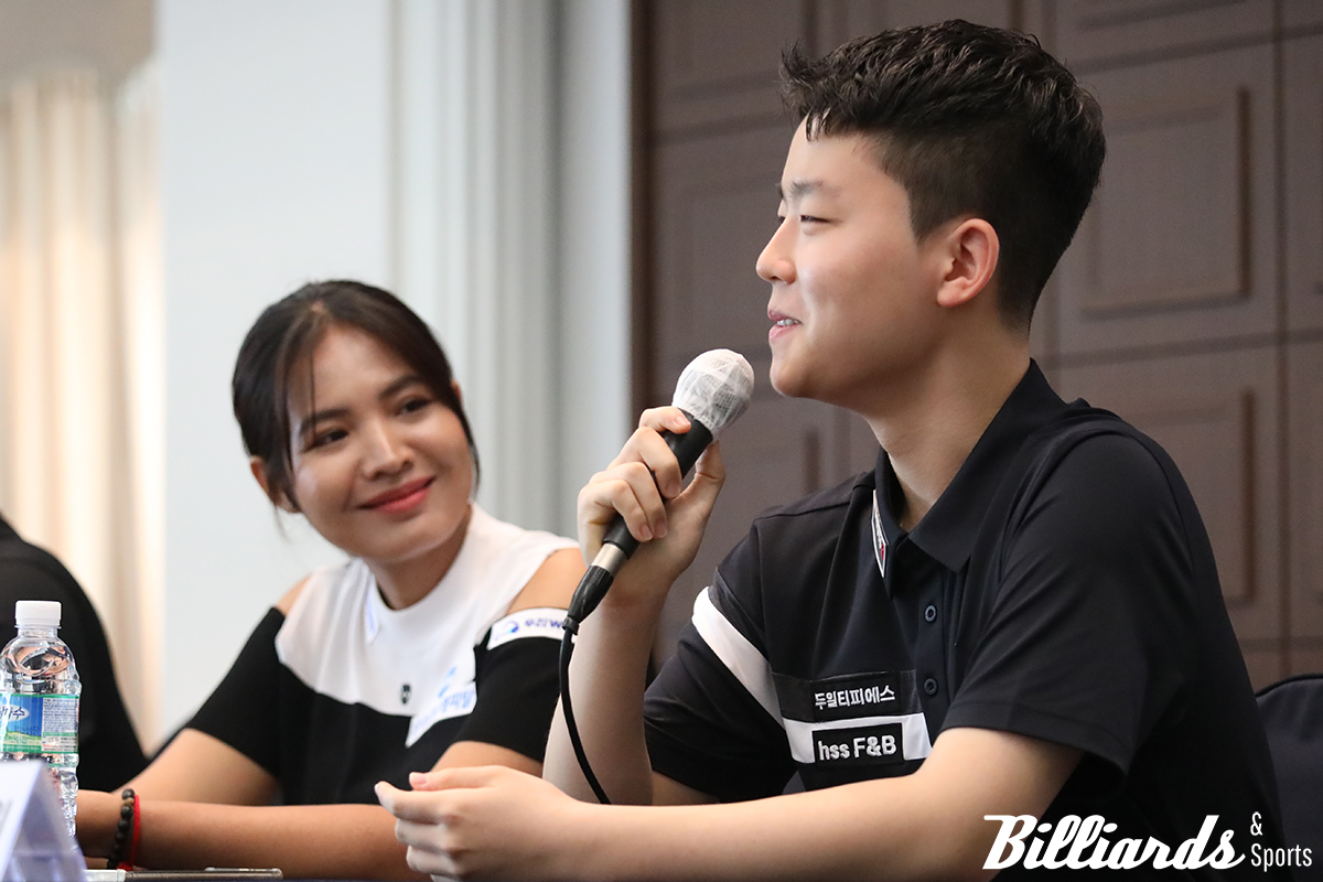 기자들의 질문에 답변하는 김영원과 그런 김영원의 모습을 엄마 미소로 바라보고 있는 스롱 피아비.