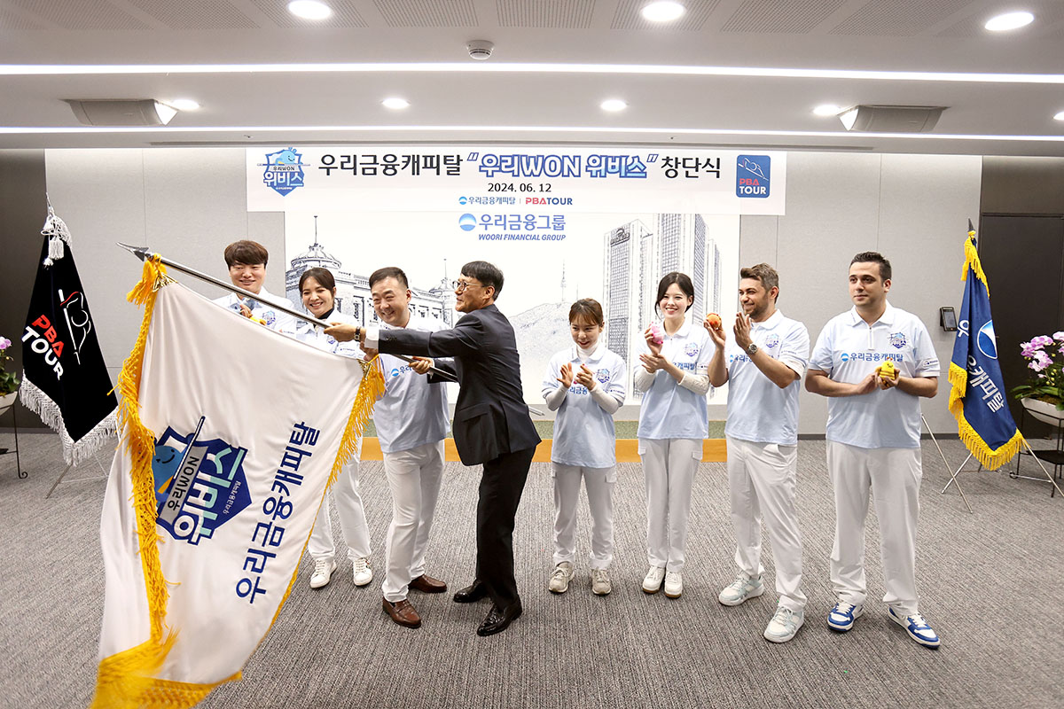 우리금융캐피탈 우리WON위비스 팀이 창단식에서 우리금융캐피탈 정연기 대표이사(구단주)와 구단기를 흔들고 있다.