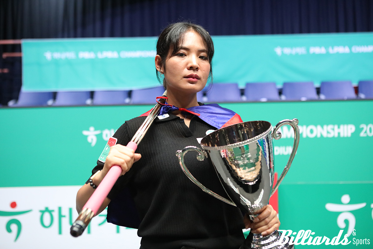 캄보디아 국기를 어깨에 두른 스롱이 크메르 여전사처럼 포즈를 취하고 있다.